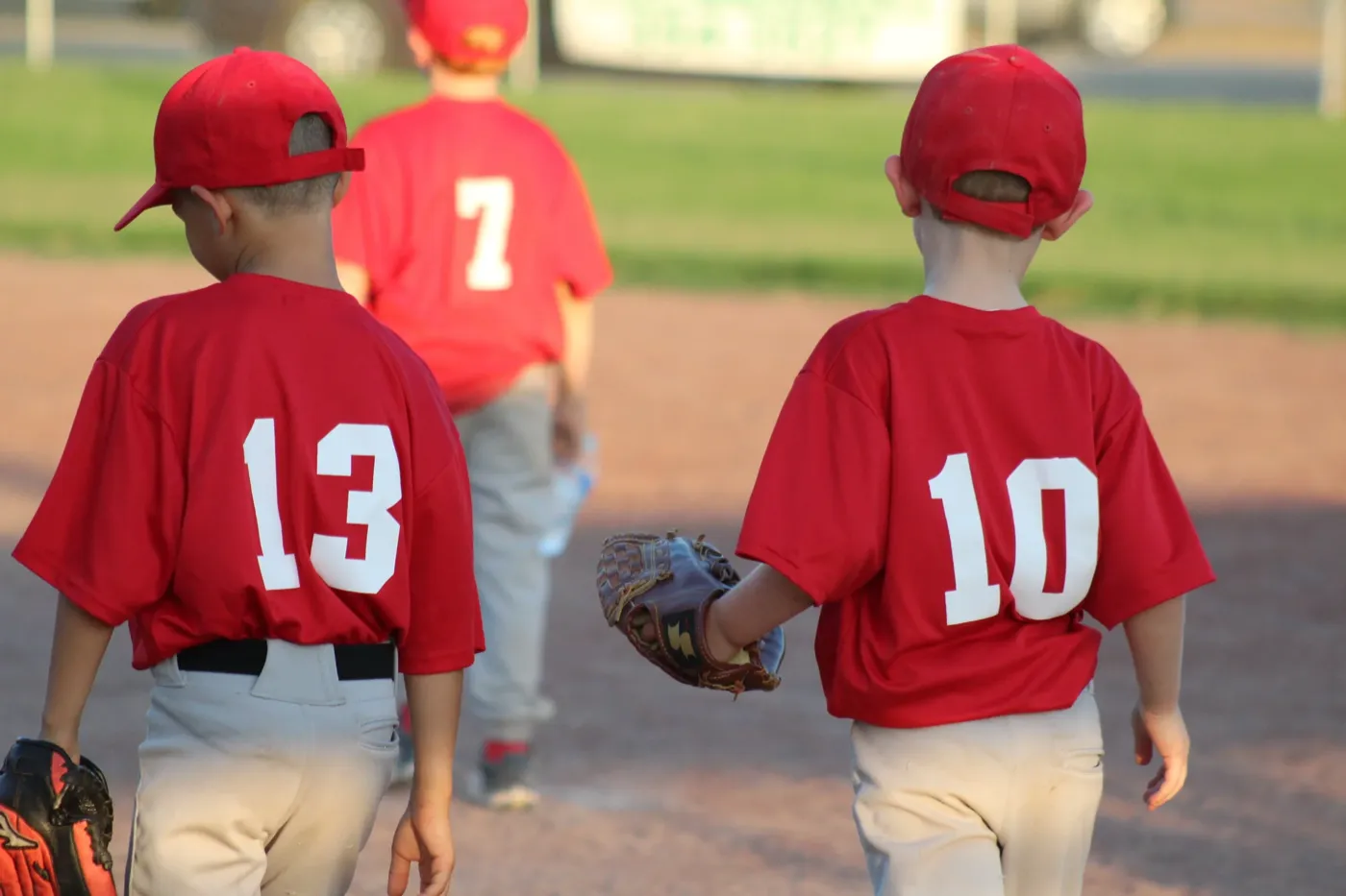 Young baseball team in red jerseys walking on the field